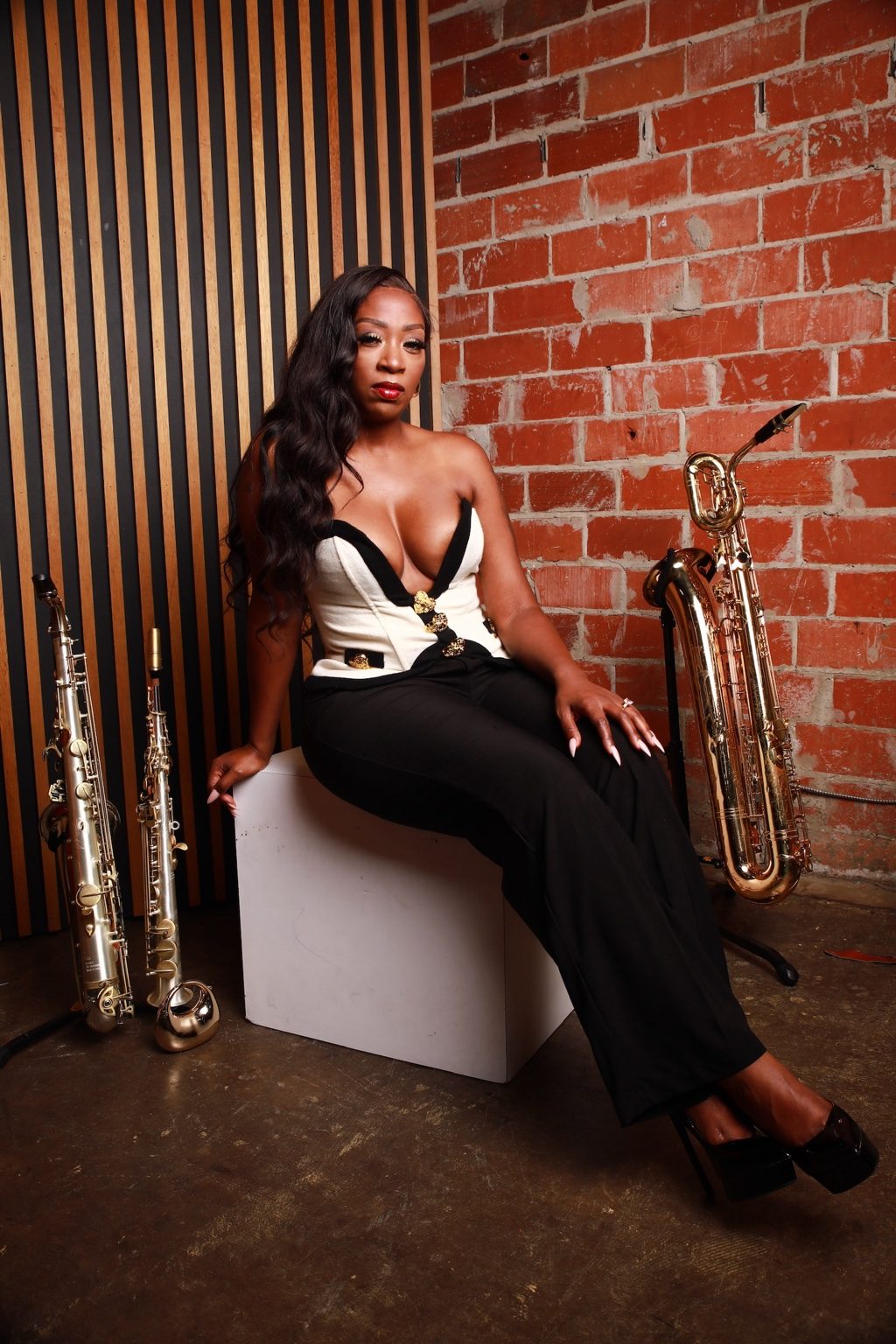 Charmin Greene with her saxophone, wearing an elegant white shirt