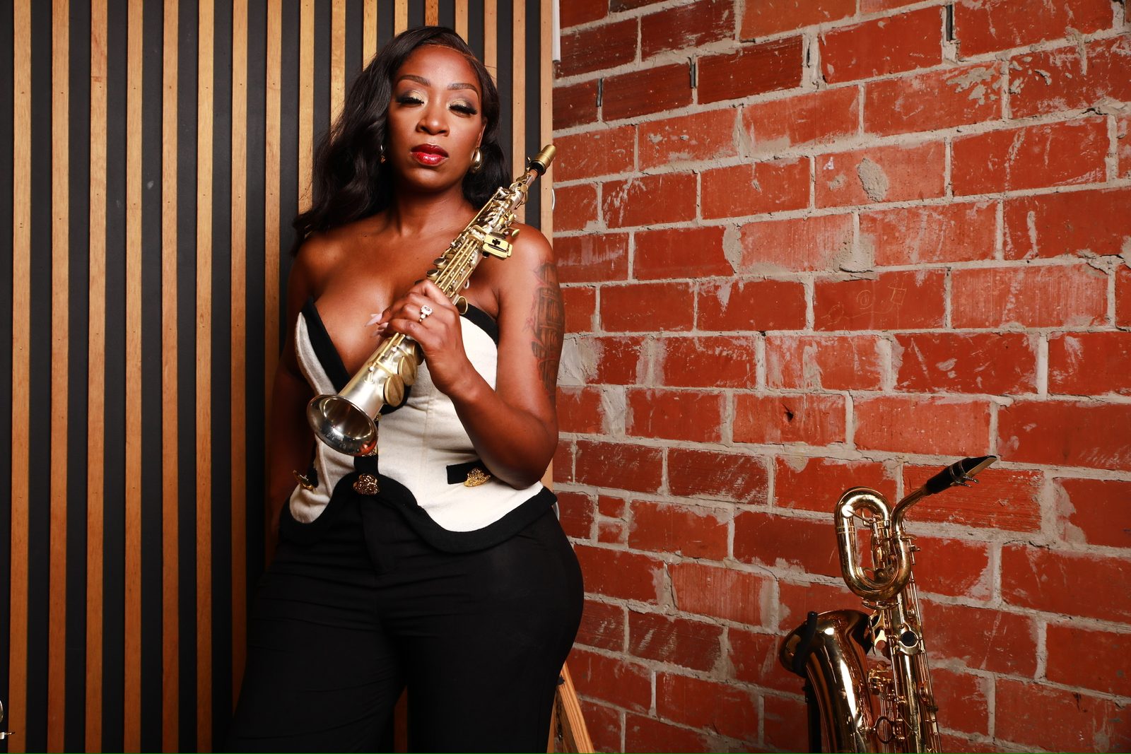 Charmin Greene with a soprano saxophone in a studio portrait